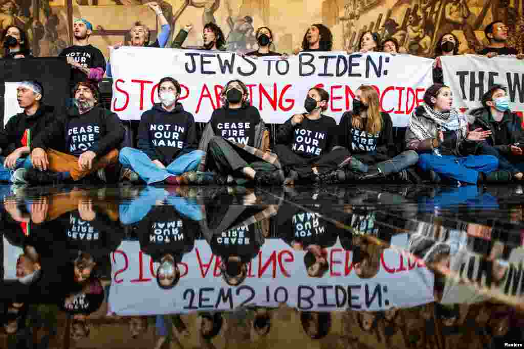 Demonstrators protest inside the Rockefeller Center asking for a ceasefire in the ongoing conflict between Israel and the Palestinian Islamist group Hamas, as U.S. President Joe Biden attends an interview in midtown Manhattan, in New York, Feb. 26, 2024.