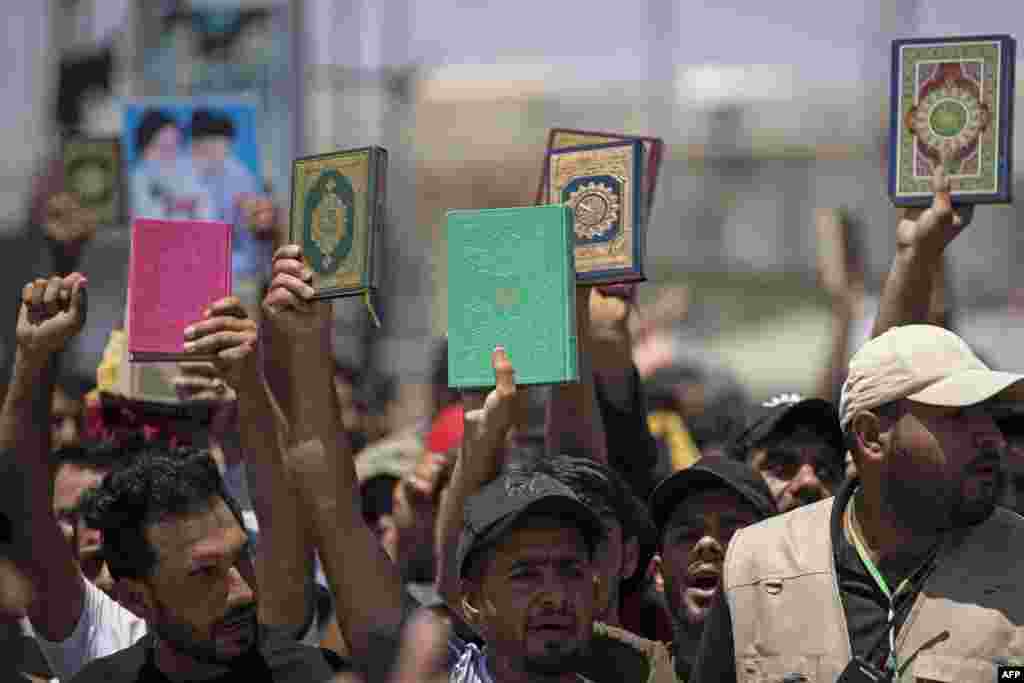 Supporters of Iraq's Sadrist movement hold up the Koran during a protest in Basra denouncing the burning of Islam's holy book in Sweden. The protest came a day after an Iraqi citizen living in Sweden, Salwan Momika, 37, stomped on the Islamic holy book and set several pages alight in front of the capital's largest mosque. 