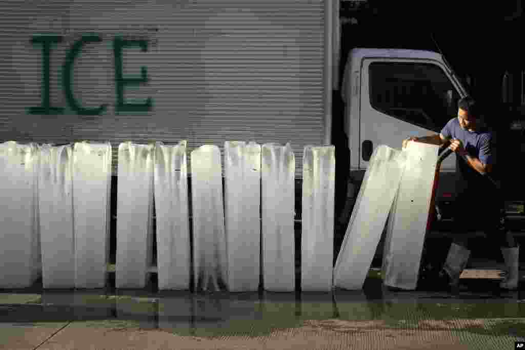 A man arranges blocks of ice before he delivers it to fish vendors at a market in Manila, Philippines.