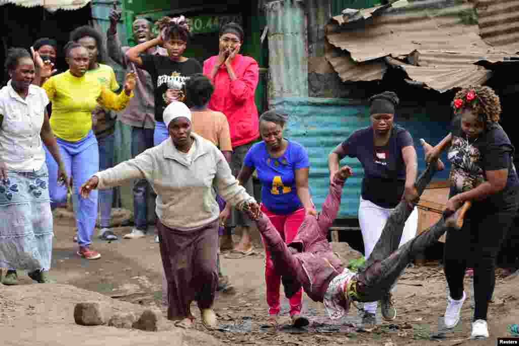 Women carry a supporter of Kenya's opposition leader Raila Odinga, who was shot during an anti-government protest against the imposition of tax hikes by the government, in Mathare settlement in Nairobi.