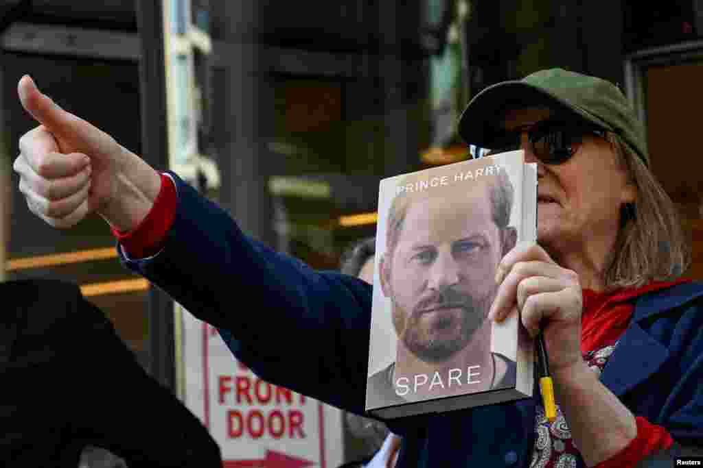A supporter of Britain's Prince Harry gives a thumbs up outside the Rolls Building of the High Court in London.