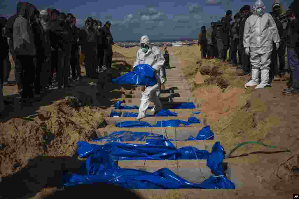 Palestinians bury the bodies of people who were killed in fighting with Israel and returned to Gaza by the Israeli military, during a mass funeral in Rafah, Gaza Strip.