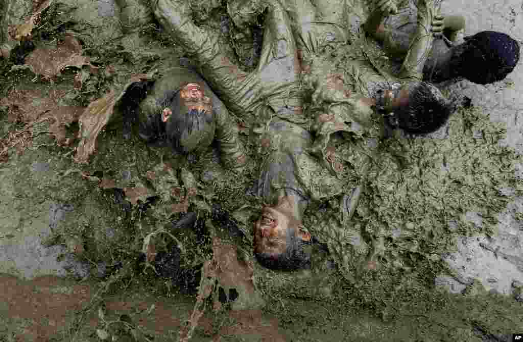 Children play in the mud in a paddy field during Asar Pandra, or paddy planting day, at Bahunbesi, Nuwakot District, 30 miles north from Kathmandu, Nepal.