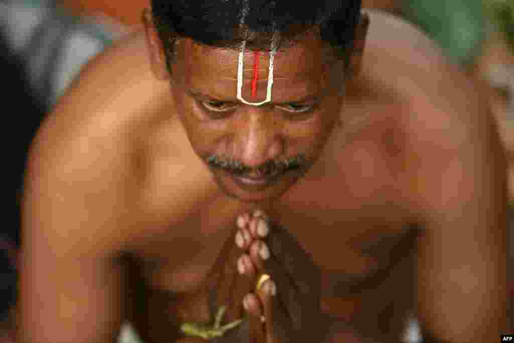 A Hindu devotee performs rituals on Mauni Amavasya at Kapaleeshwar Temple pond in Chennai, India.