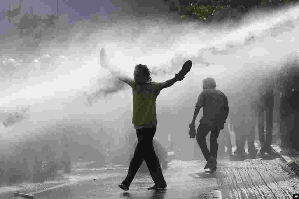 Police fire water cannons to disperse supporters of Sri Lanka main opposition during a protest rally against high taxes and increases in electricity and fuel charges, in Colombo.