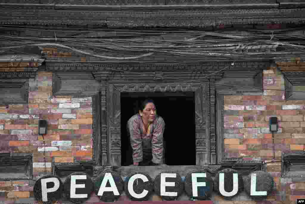 A woman looks out from a window in Bhaktapur, Nepal.