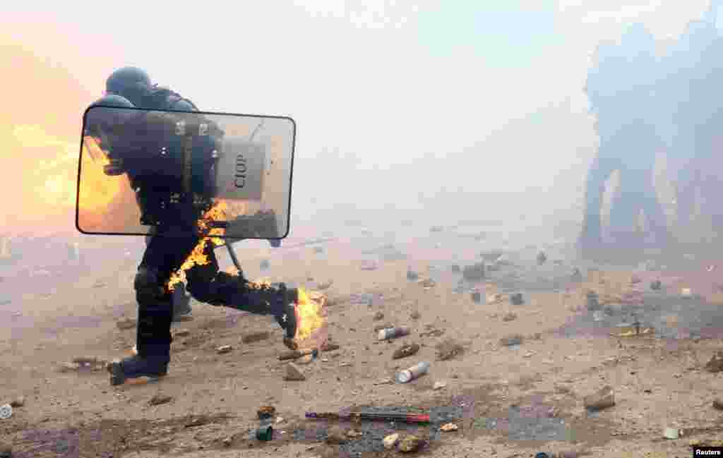 Members of the gendarmerie run during a demonstration called by the collective "Bassines Non Merci" against the "basins" on the construction site of new water storage infrastructure for agricultural irrigation in western France, in Sainte-Soline, France, March 25, 2023. 