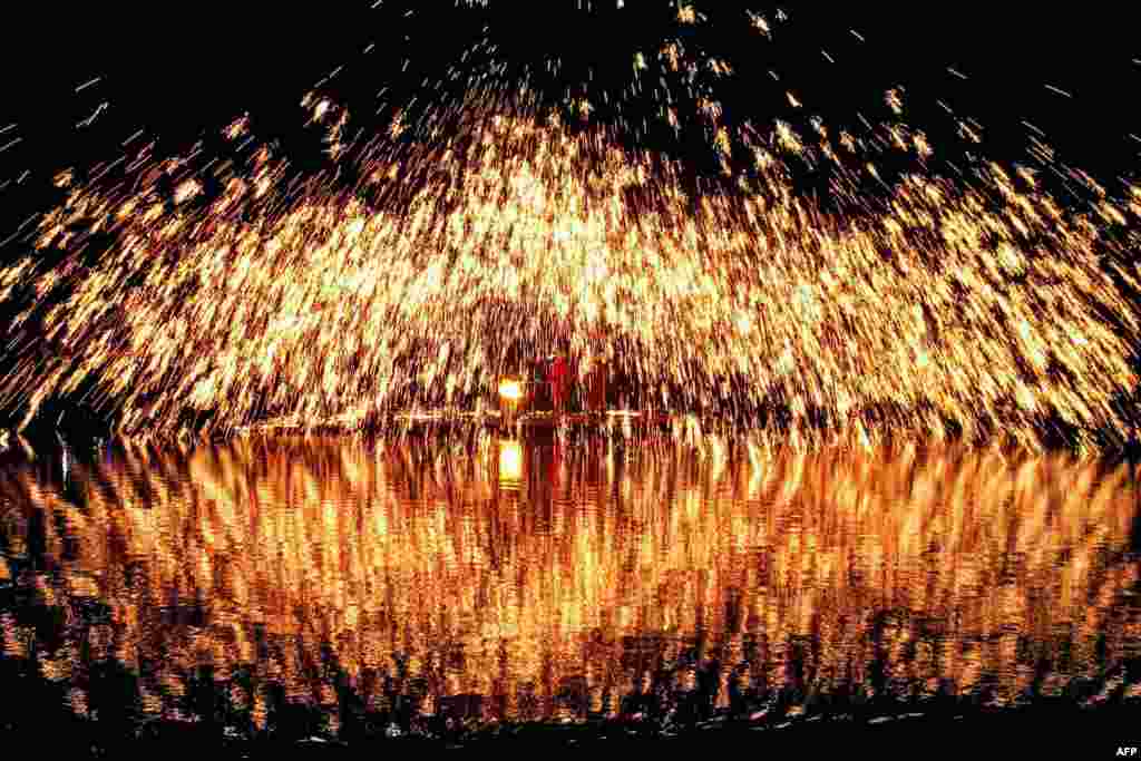 Sparks caused by molten iron are splashed during the Zhuang Song Festival, also known as "San Yue San" celebrated by ethnic minorities in Liuzhou, in southwestern China's Guangxi region, April 8, 2024.