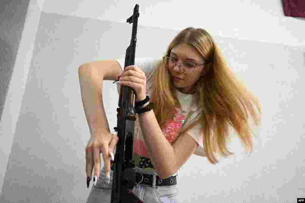 A girl dismantles a Kalashnikov rifle during a training lesson focused on the "Defence of Ukraine" at the military-patriotic center for schoolchildren in Lviv, amid the Russian invasion of Ukraine.