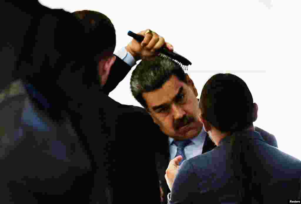 Venezuela's President Nicolas Maduro brushes his hair as he leaves the South American Summit at Itamaraty Palace in Brasilia, Brazil, May 30, 2023.