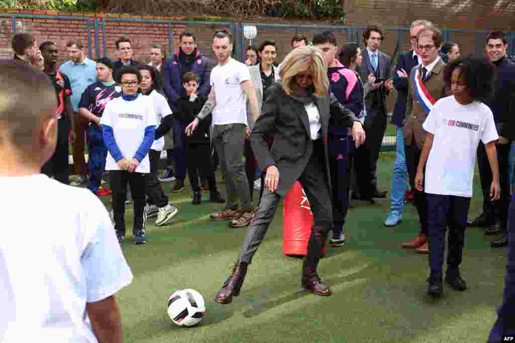 French First Lady Brigitte Macron (C) takes part in a football activity with youths during a visit the medical-educational institute (IME) Leonce Malecot in Saint-Cloud, west of Paris.