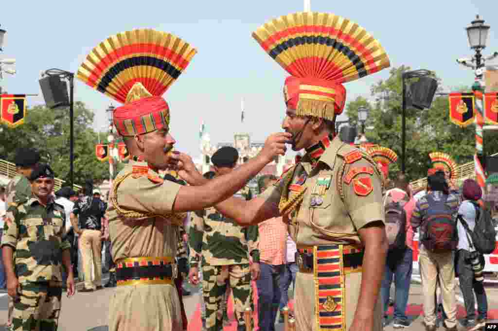 Indian Border Security Force personnel offers sweets to each other to celebrate the country's 77th Independence Day at the India-Pakistan Wagah Border post, some 35 kilometers from Amritsar.