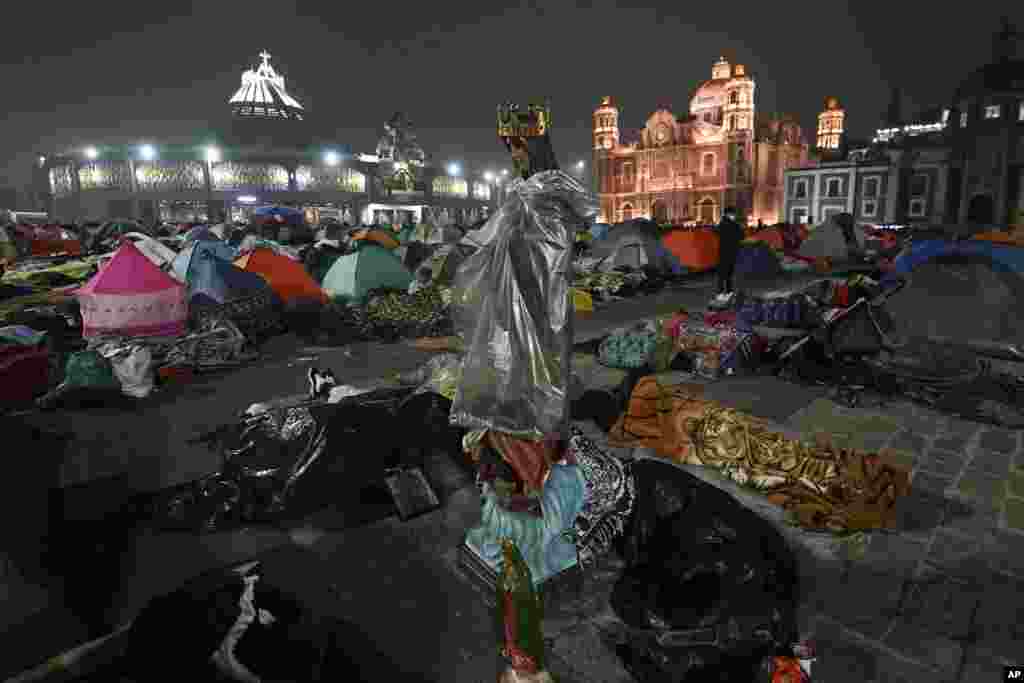 A statue of the Virgin of Guadalupe stands amid pilgrims sleeping outside the Basilica of Guadalupe on her feast day in Mexico City.