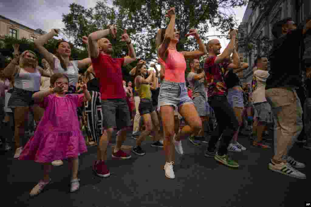 People dance on Calea Victoriei, a main avenue in Bucharest, Romania, during the Dance Night event, Aug. 26, 2023.