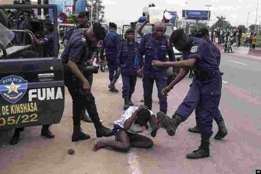 Security forces assault a supporter of presidential candidate Martin Fayulu during clashes outside his party's headquarters, in Kinshasa, Democratic Republic of the Congo. Fayulu is one of five opposition candidates who say last week's election should be rerun and question its credibility. 