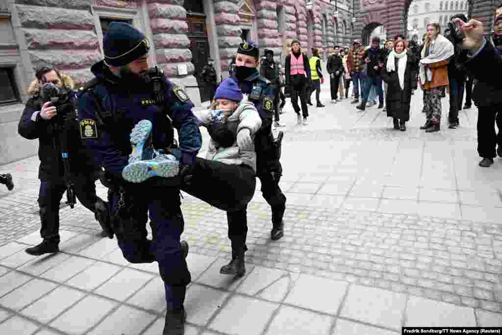 Police officers removes Greta Thunberg as she demonstrates outside the Swedish parliament building together with a group of climate activists in Stockholm.