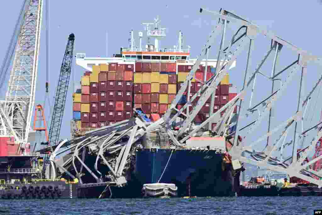 Workers continue to clear the wreckage of the Francis Scott Key Bridge and the container ship Dali in Baltimore, Maryland. The first cargo ship passed through a temporary channel in Baltimore on April 25, after being trapped in the harbor since the bridge collapsed on March 26, 2024.