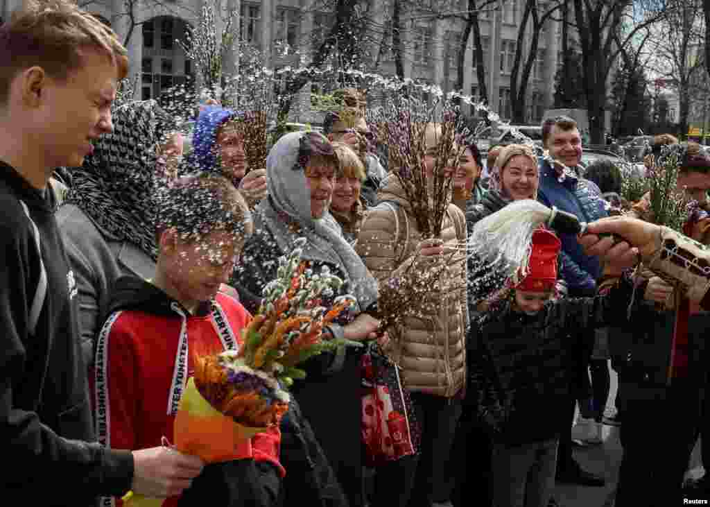 An Orthodox priest sprays holy water on believers after a service which marks the Orthodox feast of Palm Sunday in Kyiv, Ukraine.