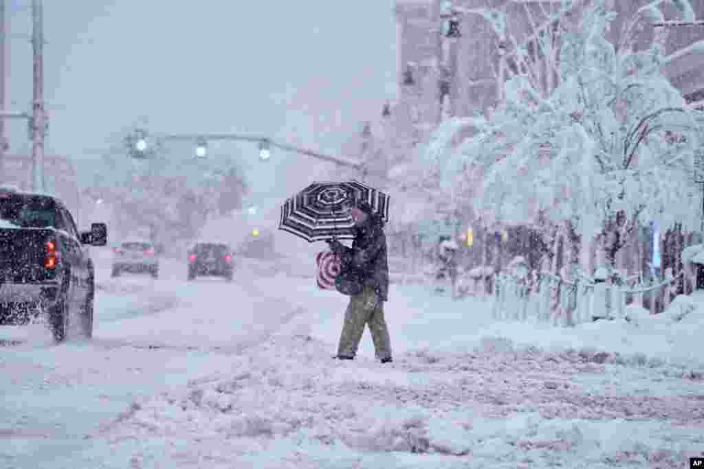 A man crosses a snow-covered street in Pittsfield, Massachusetts. The New England states and parts of New York are bracing for a winter storm due to last into Wednesday. 