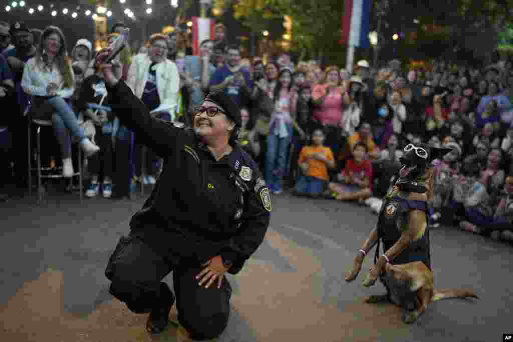 Police dog instructor Adriana Ayala takes a selfie with her dog during an exhibition to celebrate the 212th Anniversary of Paraguay´s Independence from Spain, in Asunción, Paraguay, May 14, 2023.