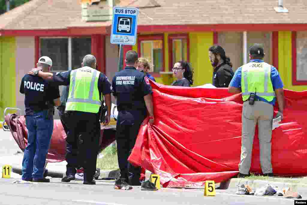 A police officer is consoled after a deadly incident where a car ran into pedestrians near Ozanam Center, a shelter for migrants and homeless, in Brownsville, Texas, May 7, 2023.