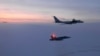 FILE - In this March 9, 2020, photo, released by the North American Aerospace Defense Command (NORAD), a Russian Tu-142 maritime reconnaissance aircraft, top right, is trailed near the Alaska coastline.