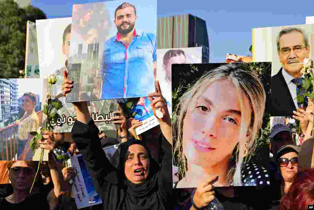 Relatives of victims of the deadly 2020 Beirut port explosion react as they hold portraits of loved ones to mark the third anniversary of the massive blast, outside the port of Beirut, Lebanon.
