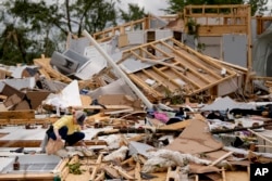 Valerie Bernhardt mira a través de los escombros en su casa dañada por una tormenta el jueves 9 de mayo de 2024 en Columbia, Tennessee, EEUU. (Foto AP/George Walker IV)