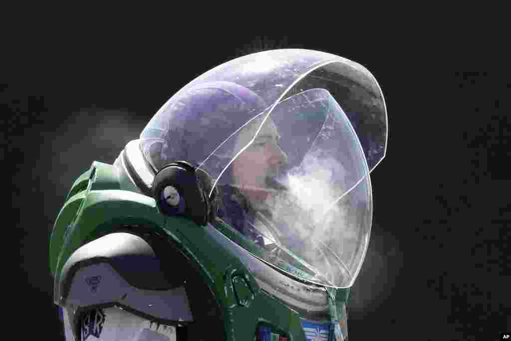 A man in a Buzz Lightyear costume smokes as he arrives to attend the MCM Comic Con at Excel in London. The event is a three-day celebration of all things pop culture.