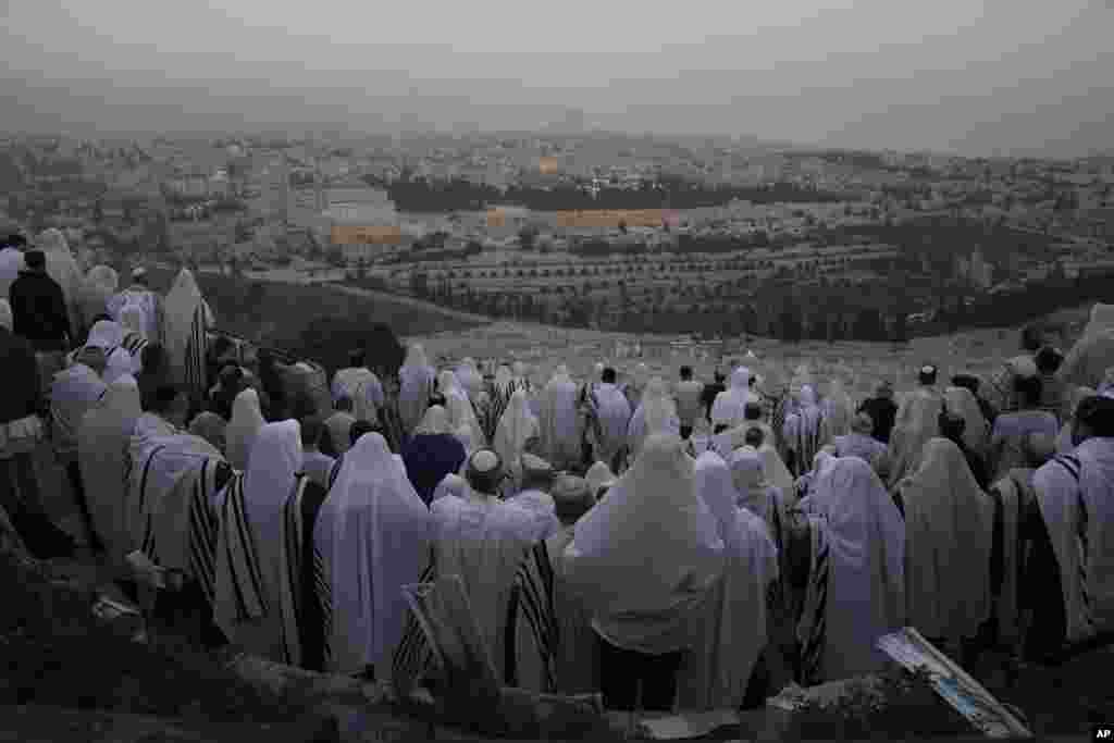 Ultra-Orthodox Jews wearing prayer shawls perform the Hoshana Rabbah prayer on the seventh day of the weeklong Jewish holiday of Sukkot, at Mount of Olives overlooking Jerusalem's Old City with the Dome of the Rock shrine.