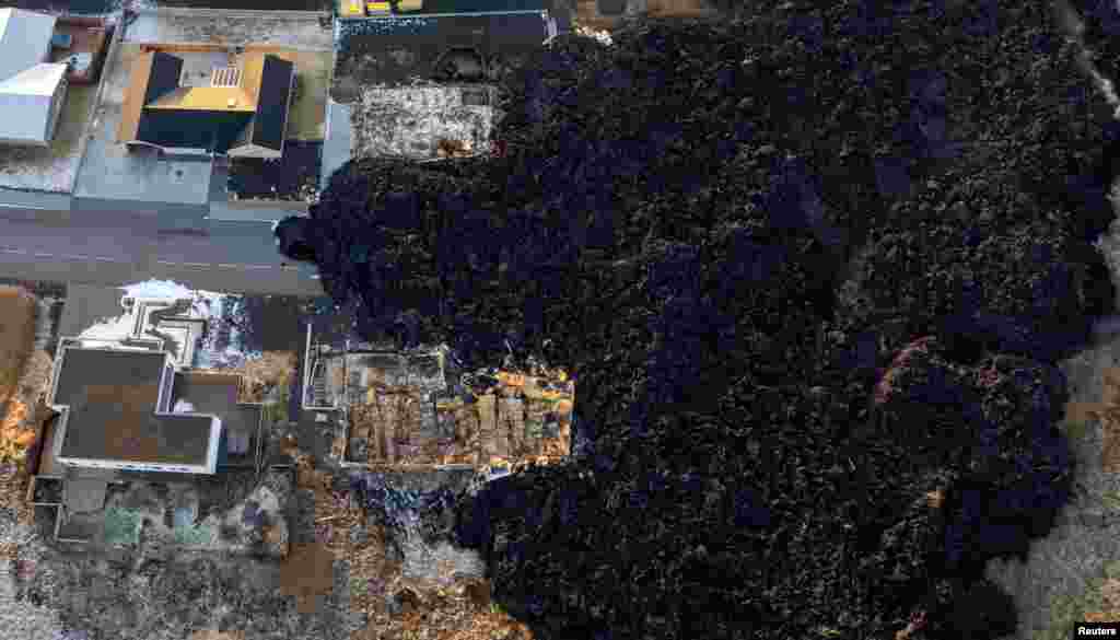 The remains of homes destroyed by a lava flow are seen following a volcanic eruption on the edge of the town of Grindavik, Iceland.