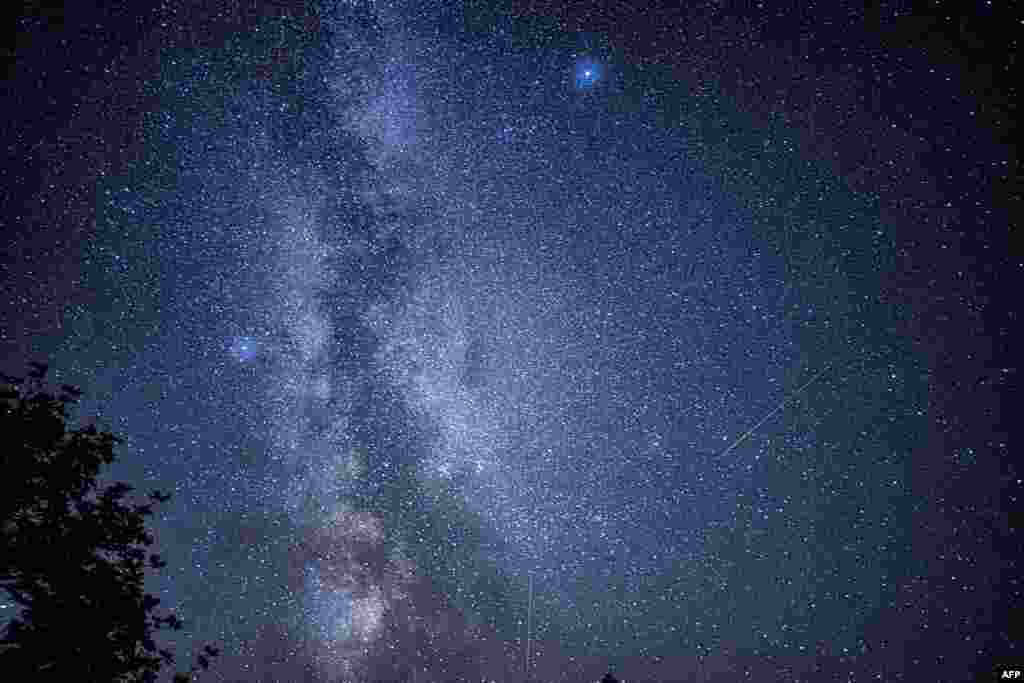 Shooting stars streak across the Milky Way during the "Nuits des étoiles" (Starry Night), a major annual celebration for astronomy enthusiasts, in Fontainebleau, southern Paris, France, Aug. 13, 2023.