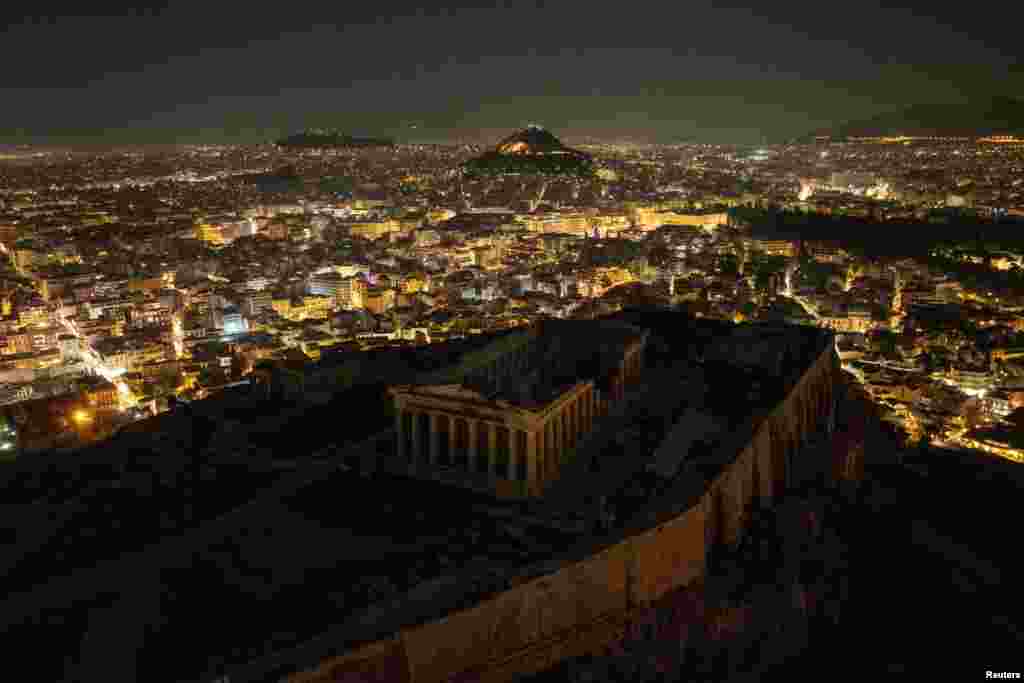 A drone view shows the ruins of the ancient Parthenon temple atop the Acropolis hill with the lights turned off during Earth Hour, in Athens, Greece, March 23, 2024.