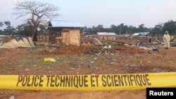 Um voluntário permanece no interior do cordão de isolamento durante a busca dos corpos de residentes, mortos na sequência de um ataque de presumíveis rebeldes islamistas das Forças Democráticas Aliadas (ADF).