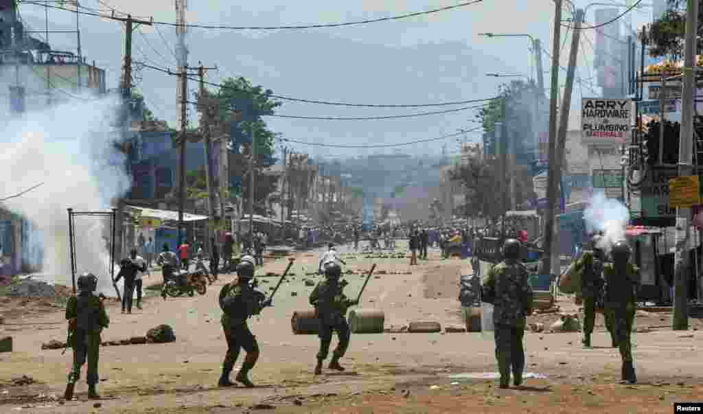 Riot police officers lob teargas canisters to disperse supporters of Kenya's opposition leader Raila Odinga of the Azimio La Umoja (Declaration of Unity) One Kenya Alliance, during protests over cost of living and Kenyan President William Ruto's government, in Kisumu.