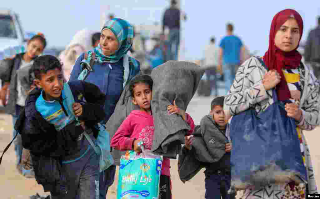 Palestinians, who were displaced by Israel's military offensive on south Gaza, make their way as they attempt to return to their homes in north Gaza through an Israeli checkpoint.