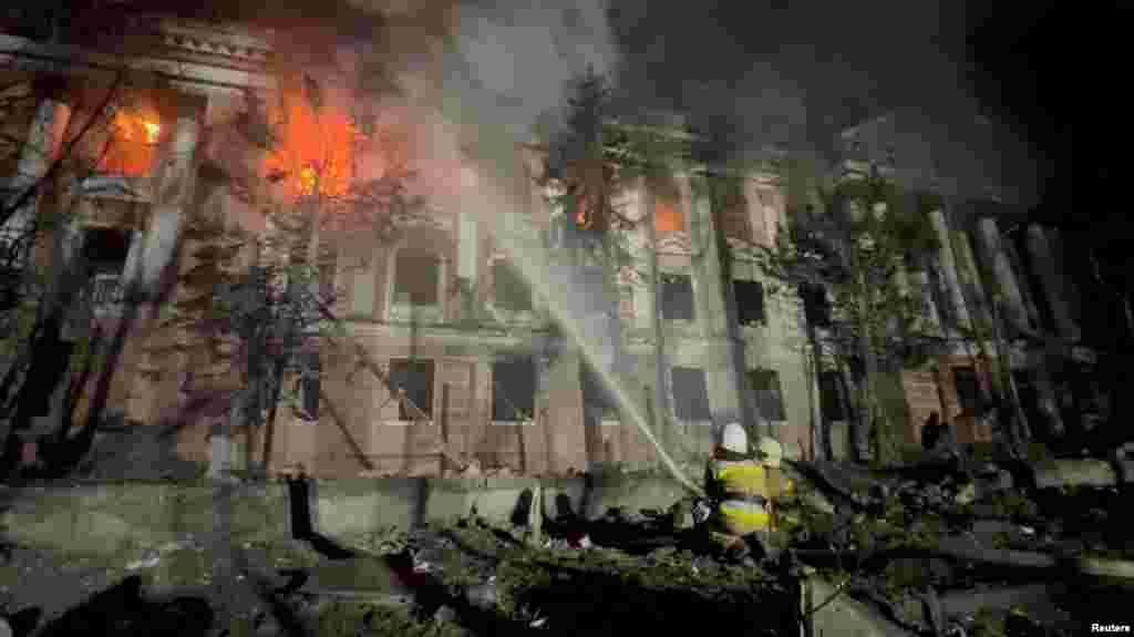 Firefighters work at a site of a building damaged by a Russian missile strike in Mykolaiv, Ukraine, in this screengrab taken from a handout video by State Emergency Service of Ukraine.