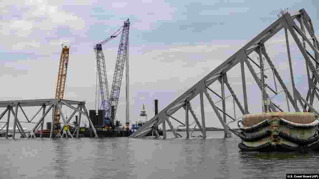 In this photo provided by the U.S. Coast Guard, Salvage operations on the Francis Scott Key Bridge take place, March 30, 2024, in Baltimore. Salvage teams used an exothermic cutting torch to systematically separate sections of the steel bridge, which will be taken to a disposal site.