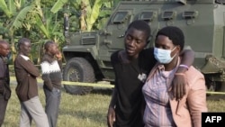 Um rapaz é confortado na Escola Secundária Mpondwe Lhubiriha. oeste do Uganda após ataque de militantes ligados ao grupo do Estado Islâmico 