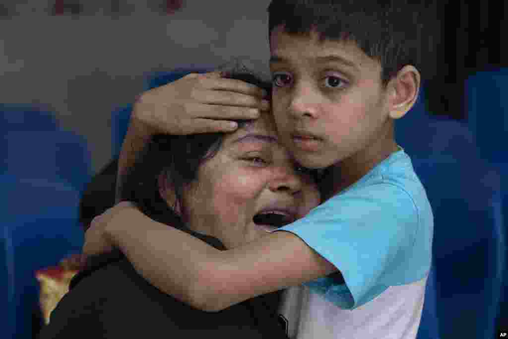 Rakibul, 6, comforts his mother Rehana mourning the death of her husband, Mohammad Zillur, at a hospital in Munshiganj, outside Dhaka. Zillur, a supporter of a candidate from the ruling Awami League, was stabbed to death as Bangladesh voted in a parliamentary election boycotted by the main opposition party.
