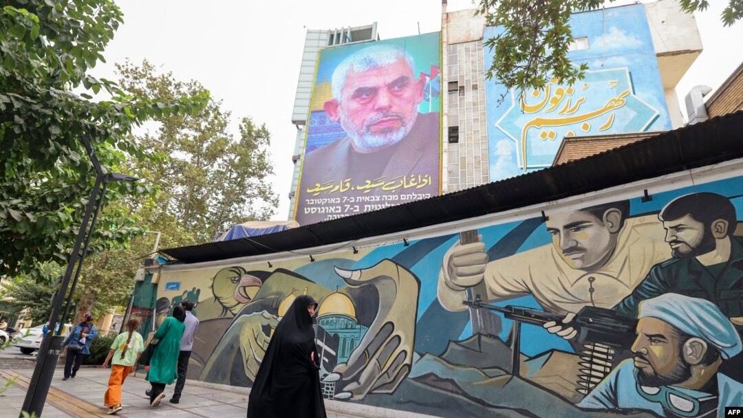 Ljudi prolaze ispod bilborda na kome je prikazan portret novoimenovanog lidera Hamasa, Jahje Sinvara (gore), na Palestinskom trgu u Teheranu, 12. avgusta 2024.