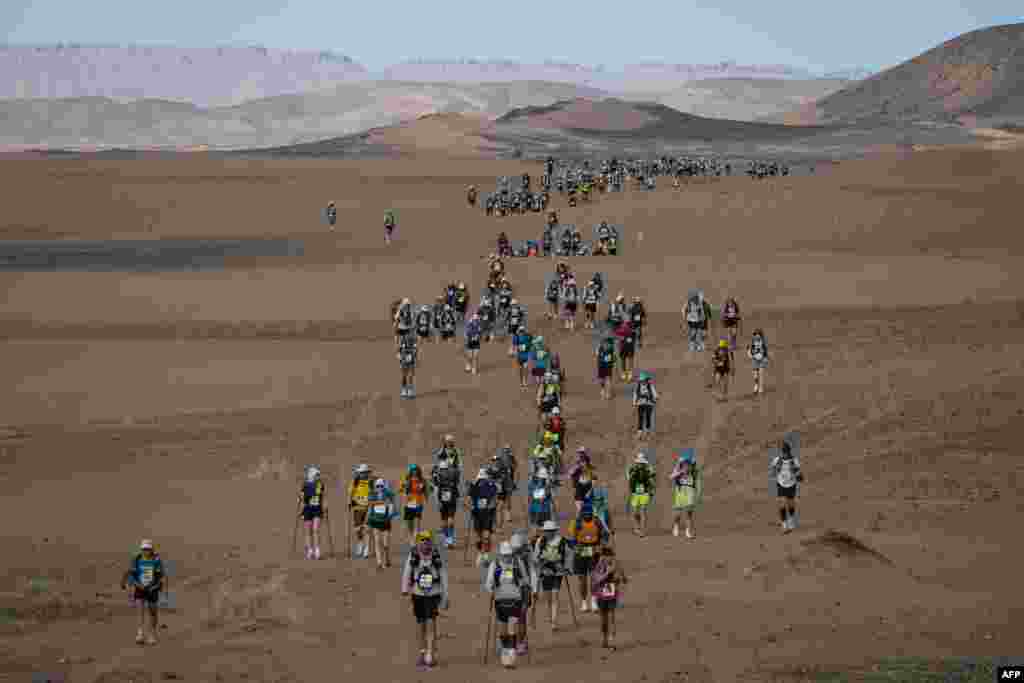 Competitors take part in stage 5 of the 37th edition of the Marathon des Sables between Jdaid and Kourci Dial Zaid in the Moroccan Sahara desert, near Merzouga central Morocco. The event is a 250-kilometer race through a formidable landscape in one of the world's most inhospitable climates.