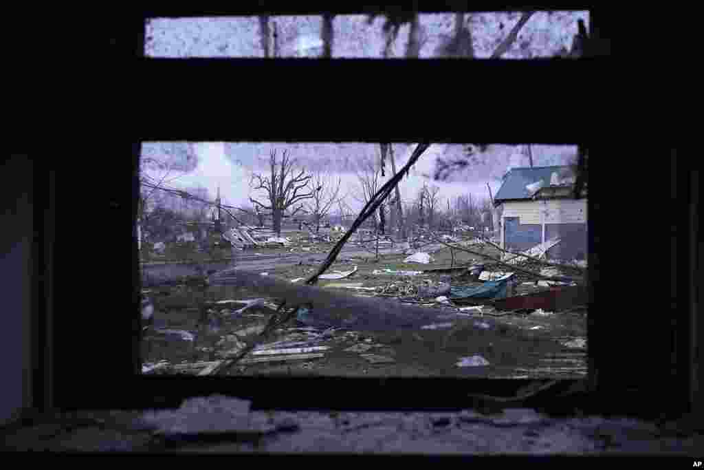 Debris is visible through the window of a damaged home following severe storms, in Lakeview, Ohio.