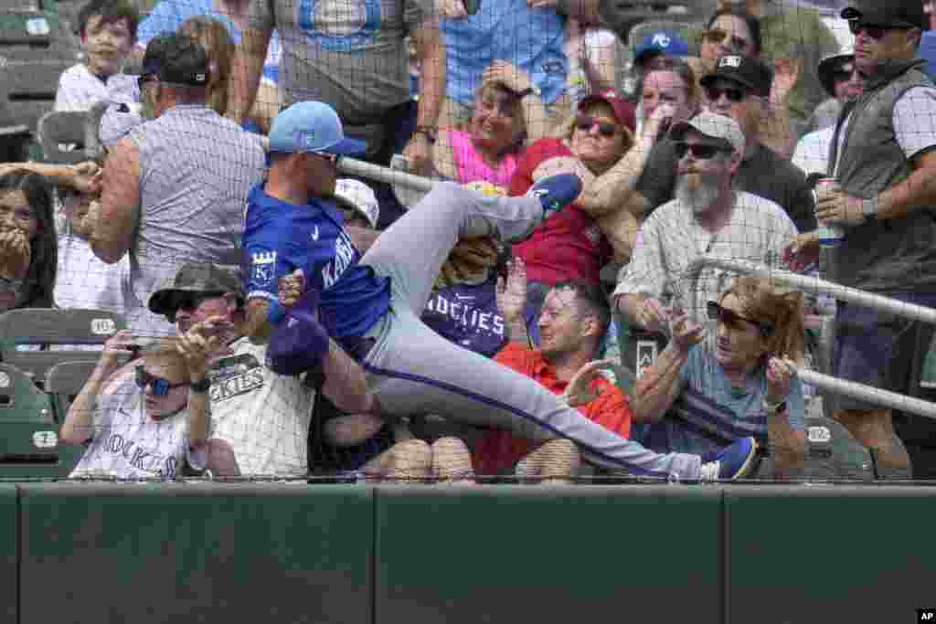 Kansas City Royals third baseman Nick Loftin crashes into the netting and the first row of fans as he failed to make a play on a foul ball hit by Colorado Rockies' Nolan Jones during the second inning of a spring training baseball game, March 12, 2024, in Scottsdale, Arizona.