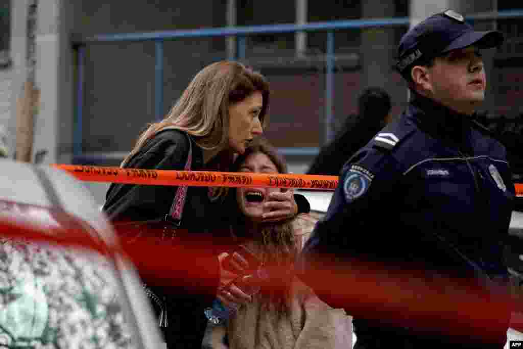 A parent escorts her child following a deadly shooting at an elementary school in Belgrade, Serbia.