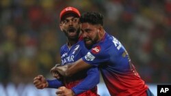 আইপিএলে চেন্নাই সুপার কিংসের ডারিল মিচেলকে আউট করে উচ্ছ্বাস রয়্যাল চ্যালেঞ্জার্স বেঙ্গালুরুর বিরাট কোহলি (বামে) ও মহম্মদ সিরাজের। বেঙ্গালুরু, ভারত। ফটোঃ ১৮ মে, ২০২৪।