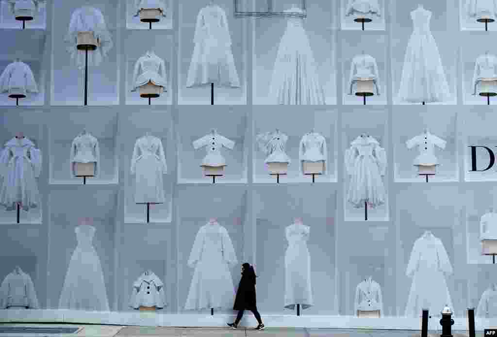 A woman walks past the holiday display of the Dior 57th Street store in New York, Dec. 11, 2023.