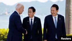 조 바이든(왼쪽) 미국 대통령과 기시다 후미오(가운데) 일본 총리, 윤석열 한국 대통령이 21일 일본 히로시마 주요7개국(G7) 정상회의 기념촬영 현장에서 담소하고 있다.