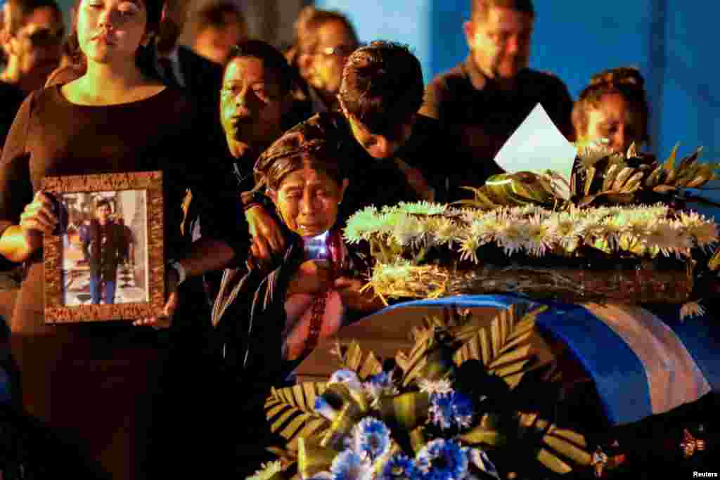 Relatives of migrants who died during a fire at a migrant detention center in the Mexican border city of Ciudad Juarez, react as caskets carrying the bodies arrive in a Mexican Air Force plane, at La Aurora International Airport, in Guatemala City, Guatemala, April 11, 2023. 