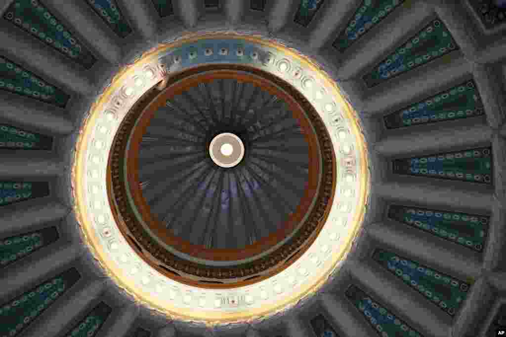 A Mississippi State Capitol facilities worker reaches out to remove a burned out light bulb in the main dome that graces the rotunda of the Capitol in Jackson, April 8, 2024.
